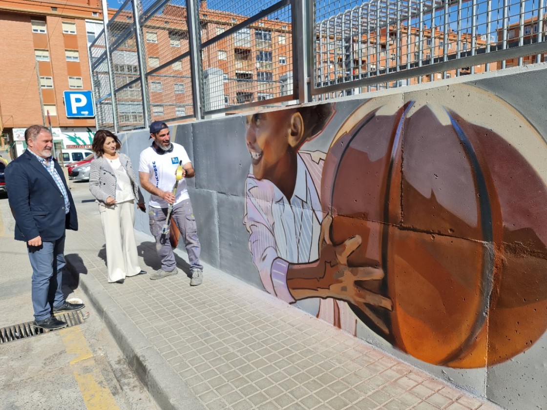 El artista Hugo Casanova decora el muro de las pistas deportivas del barrio turolense de San León
