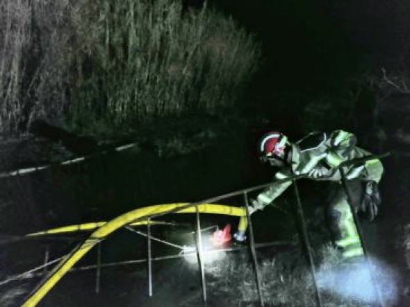 Los bomberos de la DPT evacúan el agua que sale desde el suelo y que inunda las naves del Polígono de la Laguna en Alcañiz