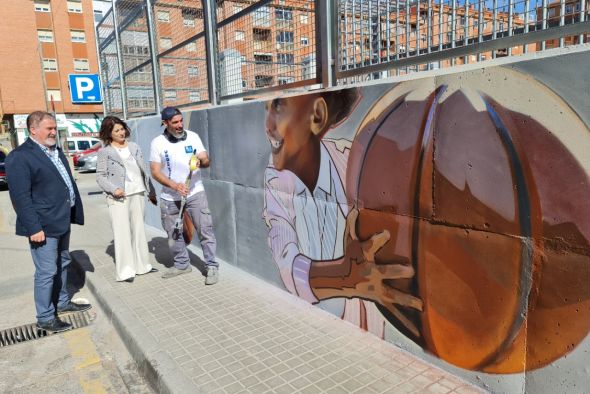 El artista Hugo Casanova decora el muro de las pistas deportivas del barrio turolense de San León