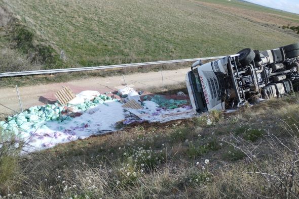 Los bomberos de la DPT auxilian a un camionero atrapado en la cabina tras volcar el vehículo