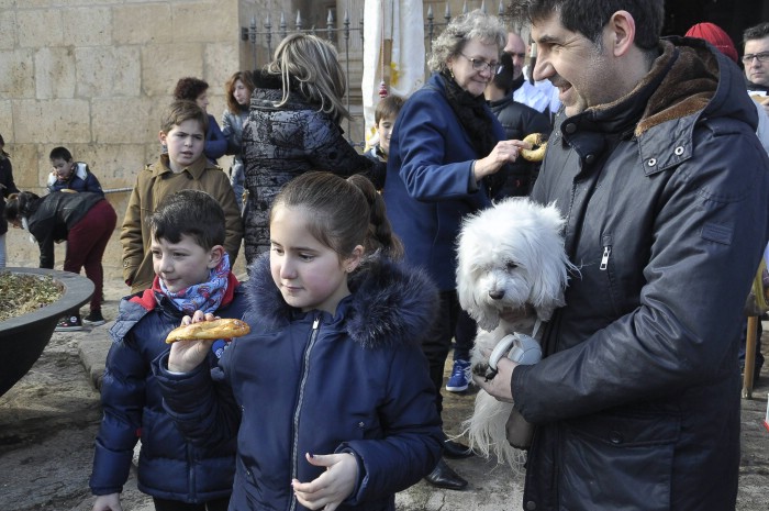 Una niña come el tradicional roscón tras bendecir a su mascota