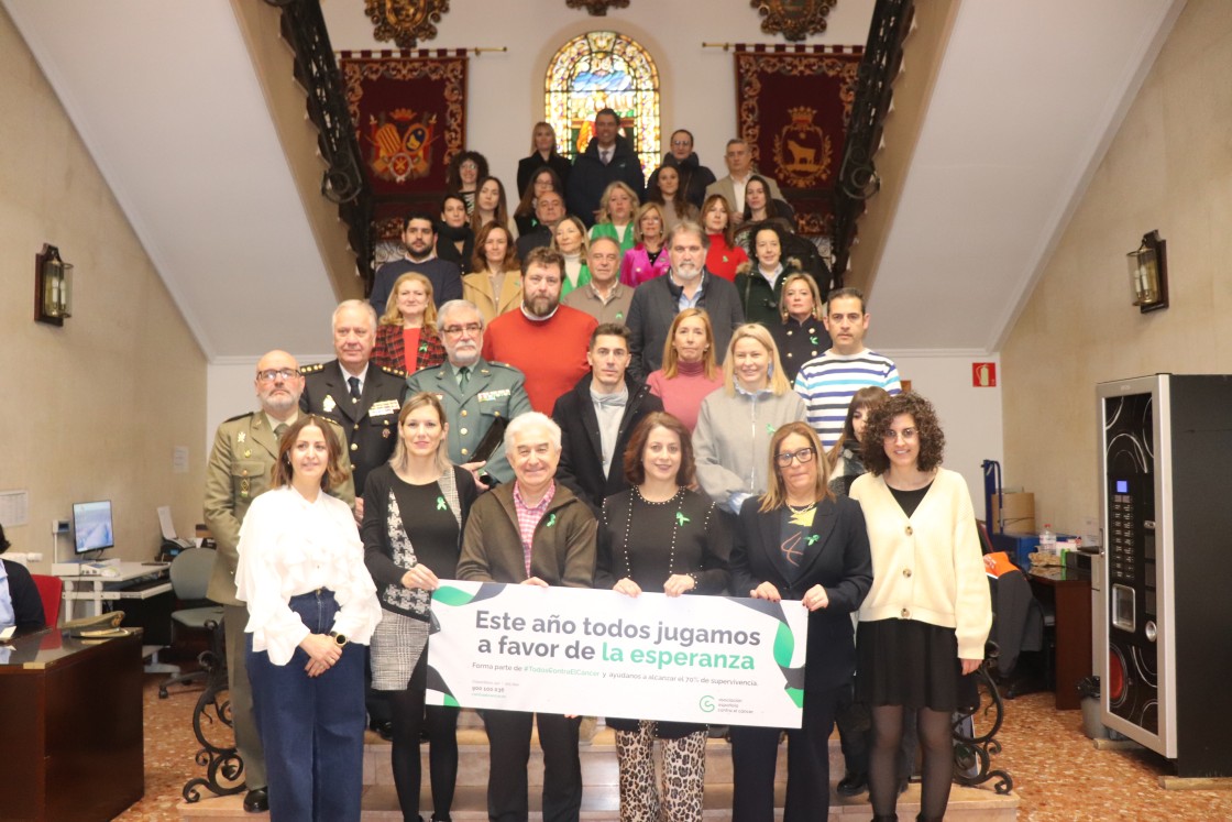 Participantes en el acto realizado en el ayuntamiento de Teruel posan con la pancarta en una foto de familia