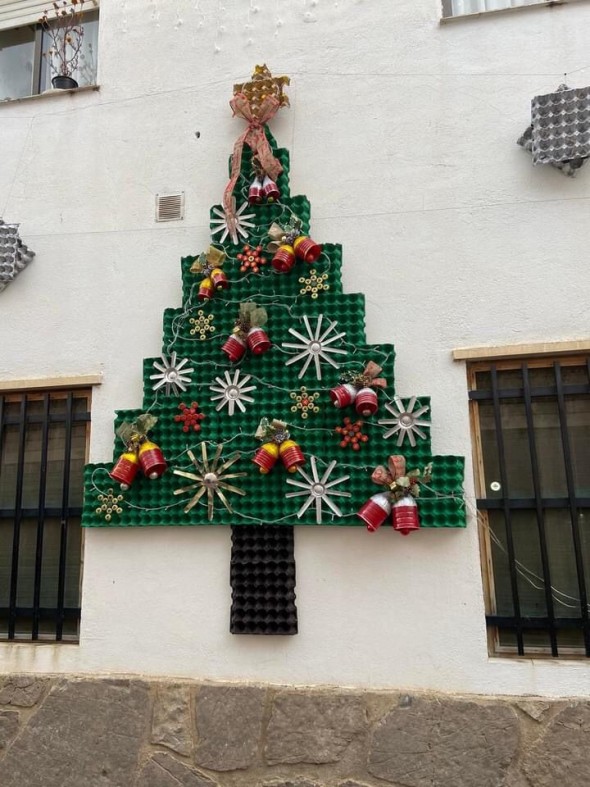 Árbol navideño hecho con material reciclado decora una fachada en Manzanera