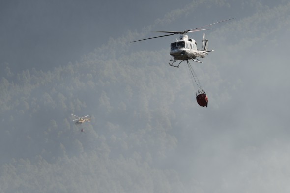 Dos helicópteros trabajan en la extinción del incendio en la zona de Los Peiros de San Agustín, en la provincia de Teruel.